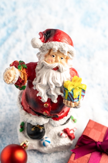 Санта-Клаус и рождественские украшения в снегу, рождественская открытка. Фото высокого качества