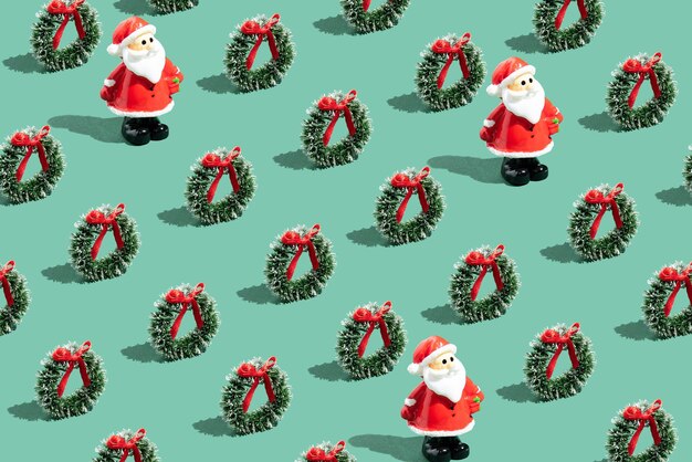 Photo santa claus and christmas wreath arranged in pattern isolated on a green background