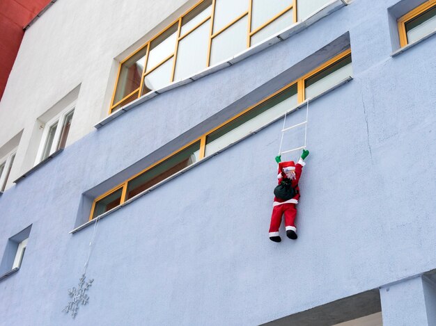 Santa Claus climbing up the wall with gifts