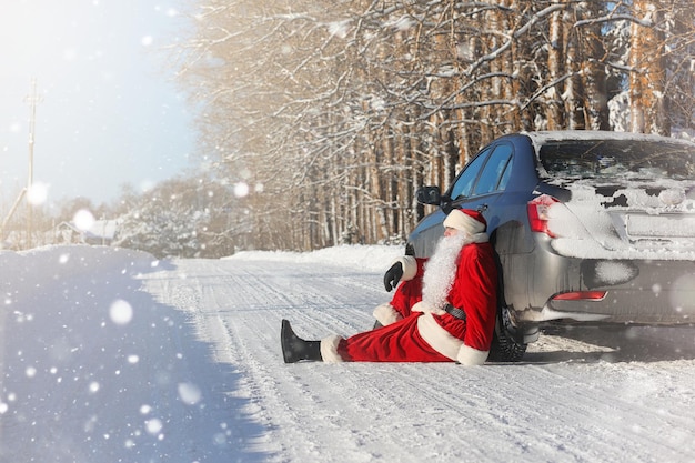 Santa Claus comes with gifts from the outdoor. Santa in a red suit with a beard and wearing glasses is walking along the road to Christmas. Father Christmas brings gifts to children.