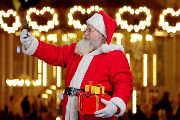 Santa Claus die een selfie op smartphone neemt.