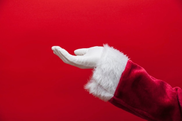 Photo santa claus empty hand against a red background