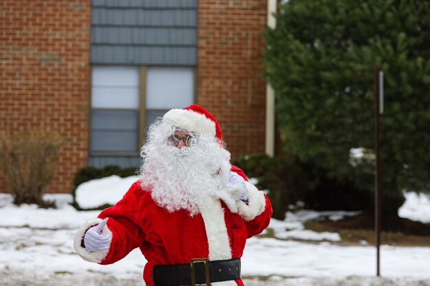 Санта-Клаус входит в дом в канун Рождества, неся мешок с подарками