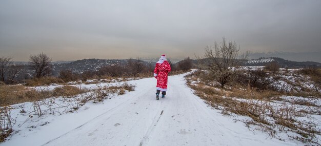 Фото Дед мороз идет по заснеженной дороге зимний пейзаж