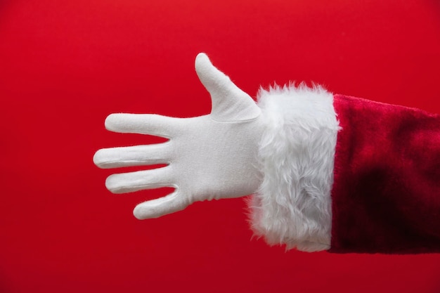 Photo santa claus hand against a red background