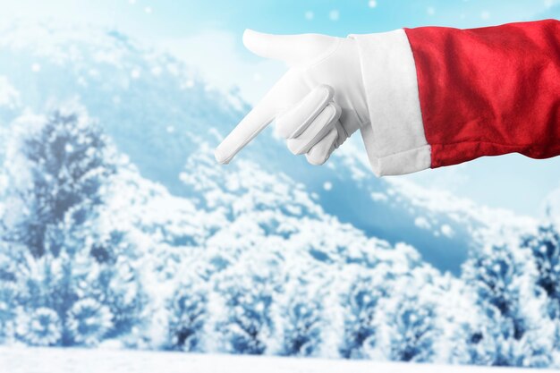Santa Claus-hand die iets met sneeuwval richt
