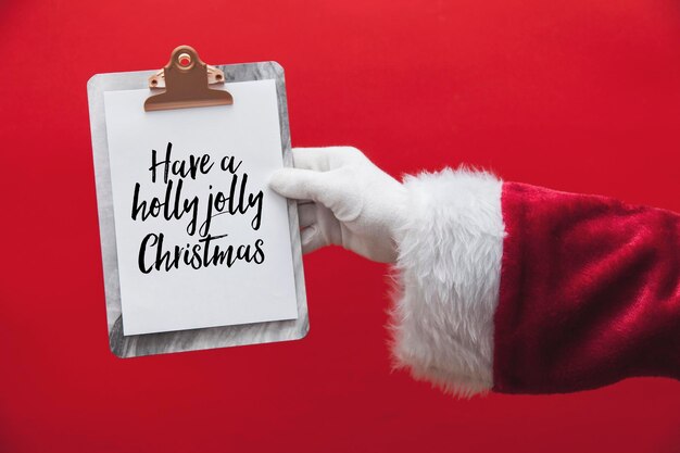 写真 クリスマスメッセージページでクリップボードを持っているサンタクロースの手