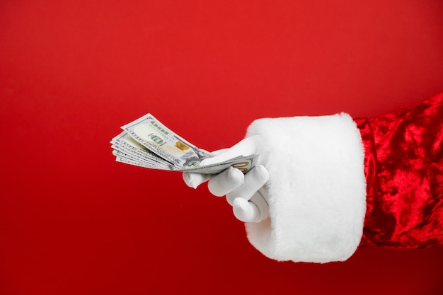 Santa Claus hand met geld op rood