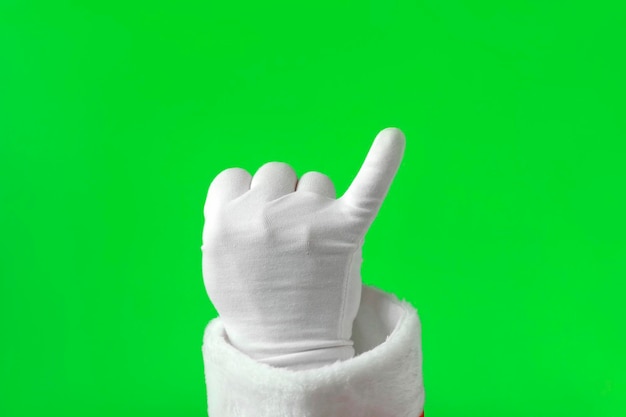Foto santa claus handen maken belofte teken gebaar geïsoleerd op groene achtergrond close-up hand in witte handschoen hand tonen pink chroma key scherm balde een vuist met uitgestrekte pinkvinger