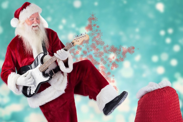 Santa Claus has fun with a guitar against light design shimmering on blue