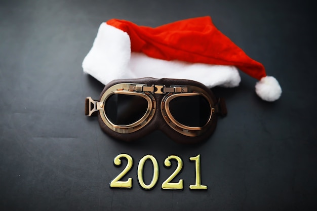 Santa Claus hat, glasses and nose with face mask on red background. Christmas or New Year celebration concept. Christmas reindeer made from protective face mask and decorations. Health care concept.