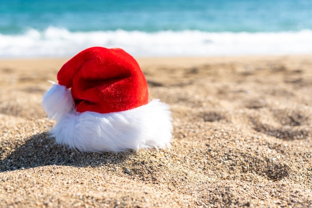 Santa Claus hat on sandy beach