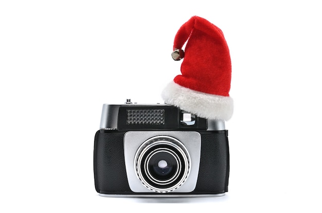 Cappello di babbo natale e macchina fotografica d'epoca per fotografare su uno sfondo bianco