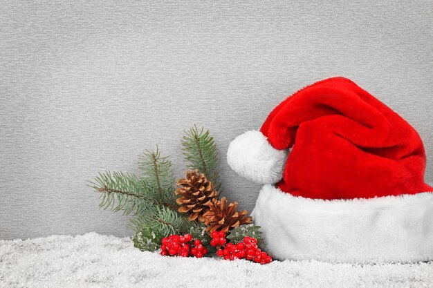 Santa Claus hat with Christmas decoration on gray background