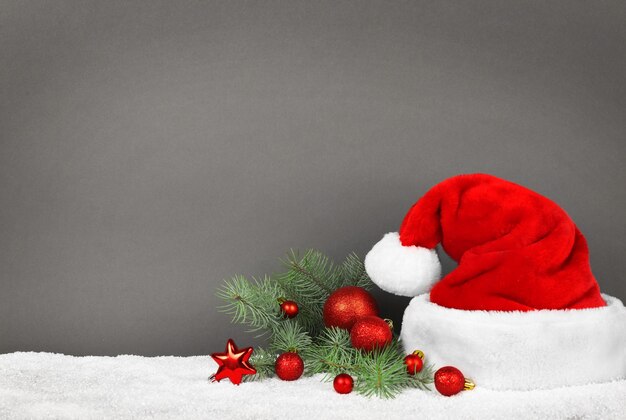 Santa Claus hat with Christmas decoration on gray background