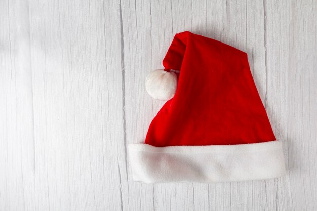 Santa Claus hat on wooden table.