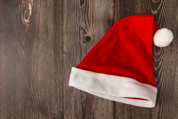 Santa Claus hat on wooden table.