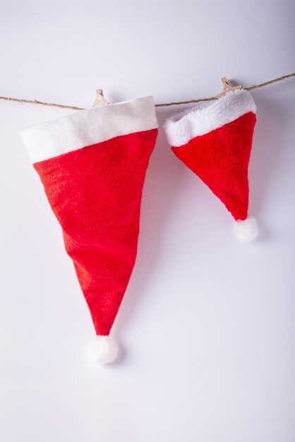 Santa Claus hats hanging on a rope on a white background