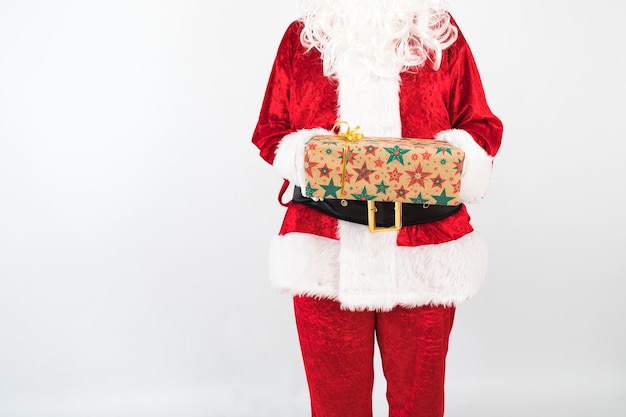 Санта-Клаус держит подарок на белом фоне