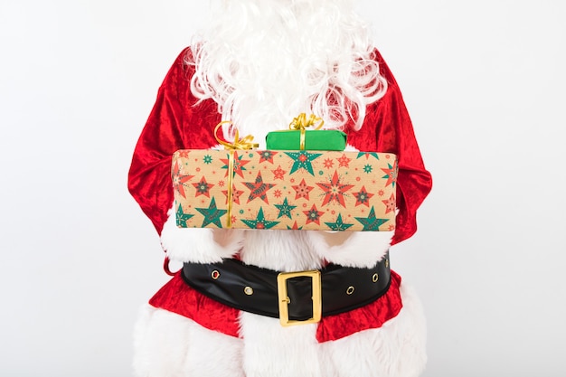 サンタクロースは白い背景に2つの贈り物を保持します