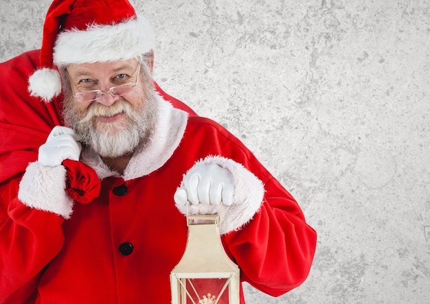 Santa claus holding a christmas lantern and gift bag