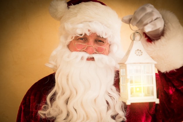 Santa Claus holding magic lantern. Christmas holiday concept