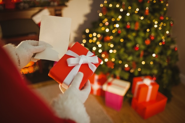 Santa claus holding paper and gift