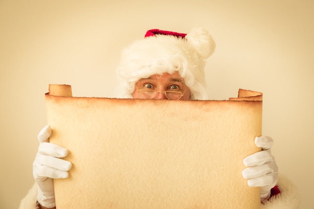 Санта-Клаус, держа пробел бумаги свитка. Концепция праздника Рождества