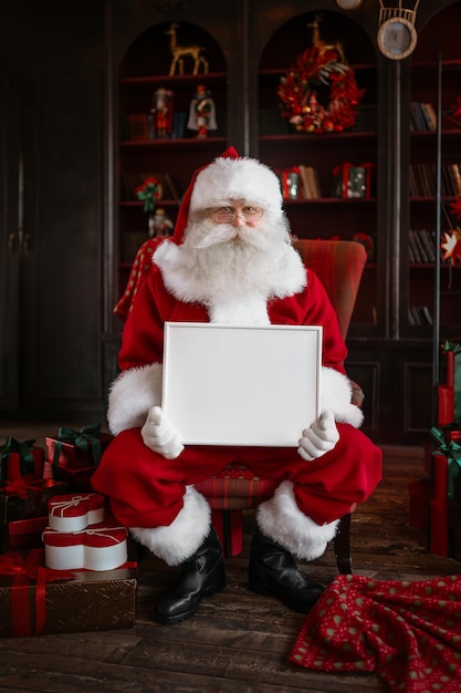 Santa Claus holding white frame in his hands