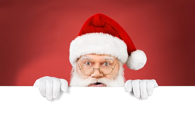 Santa claus holds a blank sign for your text