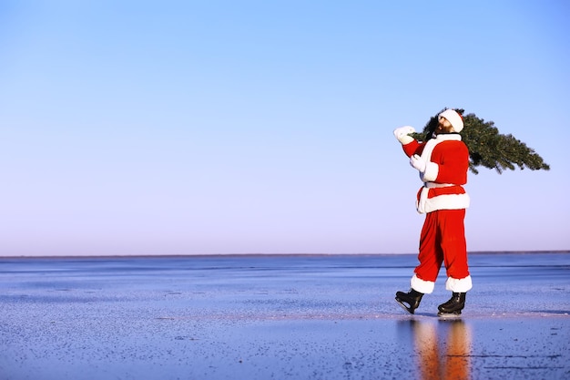 Santa Claus on ice skates goes to Christmas Santa Claus hurries to meet the New Year with gifts and Christmas tree