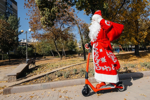 산타클로스는 어린이들에게 휴가를 위한 선물을 들고 스쿠터를 타고 바쁘다.