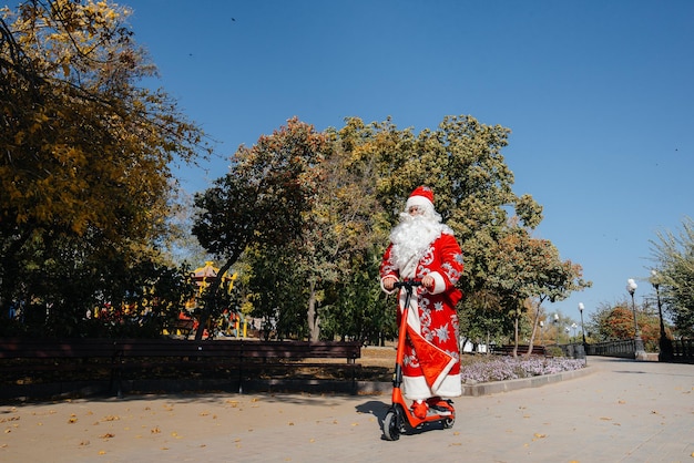 Santa Claus is in a hurry on a scooter with gifts for the holiday to the children.