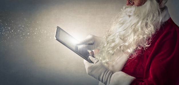 Santa claus met behulp van een tablet