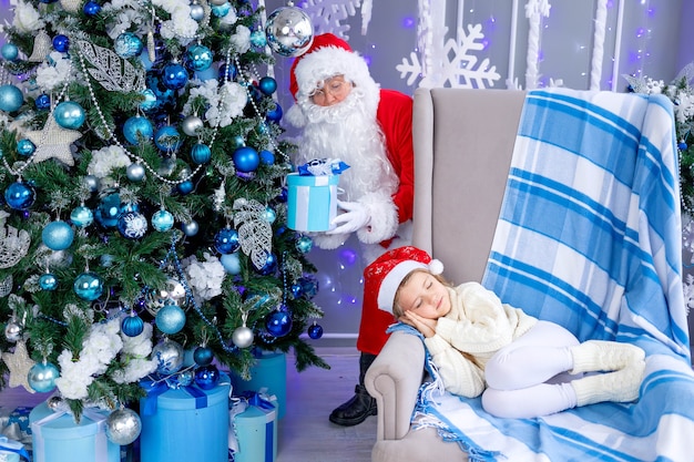 Santa Claus puts a gift under the tree while the child is sleeping