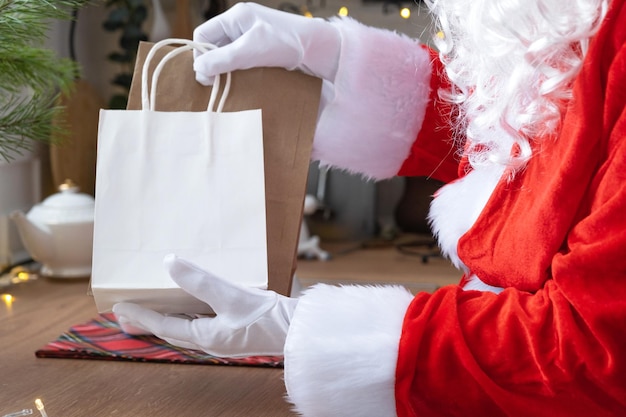 Santa claus puts it on kitchen table and takes away paper bags
with craft gift homemade cakes and food delivery shopping packaging
recycling handmade delivery for christmas and new year