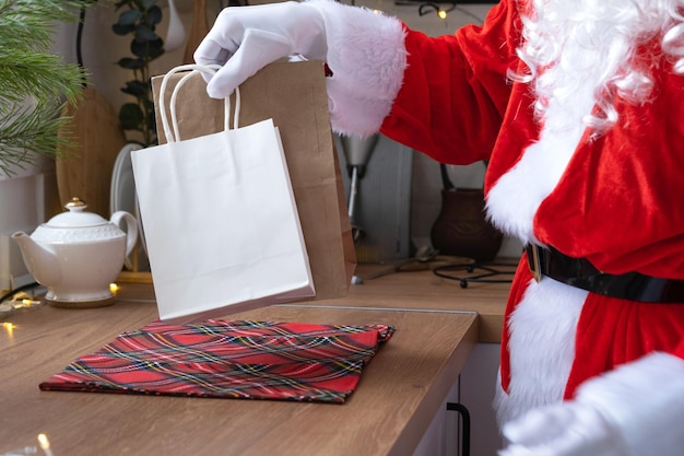 Santa claus puts it on kitchen table and takes away paper bags\
with craft gift homemade cakes and food delivery shopping packaging\
recycling handmade delivery for christmas and new year