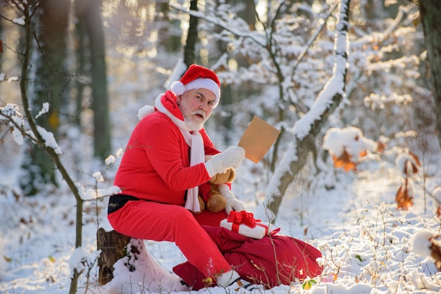 Santa claus read christmas wish list in the snow forest