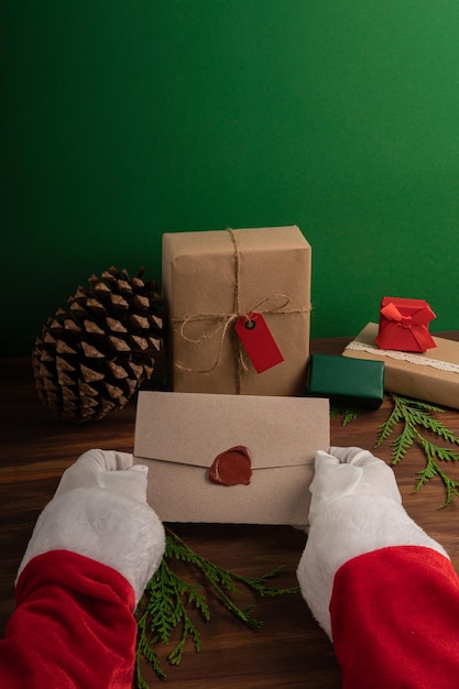 Santa Claus reading children wishes on Christmas eve over a wood and green backdrop