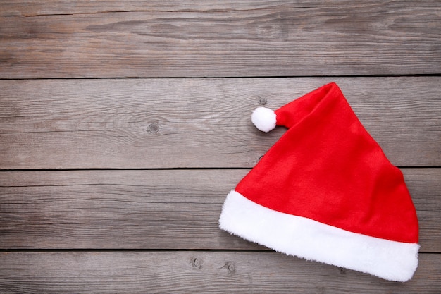 Foto cappello rosso di babbo natale su fondo di legno grigio