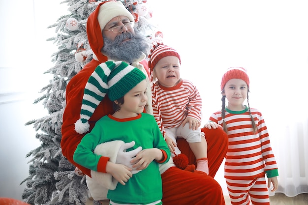 Santa Claus's helpers.Schattige kinderen in kerst elf kostuums in een kamer prachtig ingericht voor Kerstmis. Tijd van wonderen. Cadeautjes van Sinterklaas.