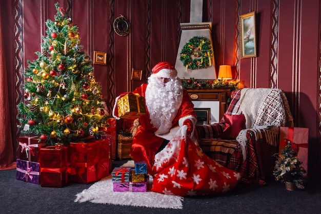 Santa Claus sitting next to a Christmas tree