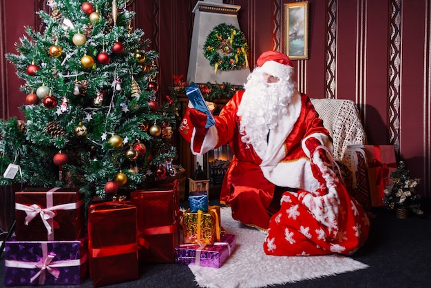 Santa Claus sitting next to a Christmas tree