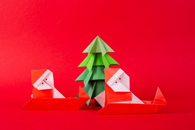 Photo santa claus on a sleigh with tree origami. christmas concept winter crafted decorations studio shot