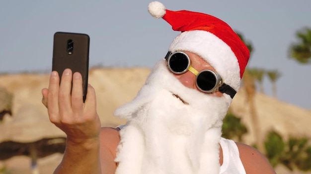 Photo santa claus takes selfie santa summer vacation santa claus blogger funny santa in sunglasses