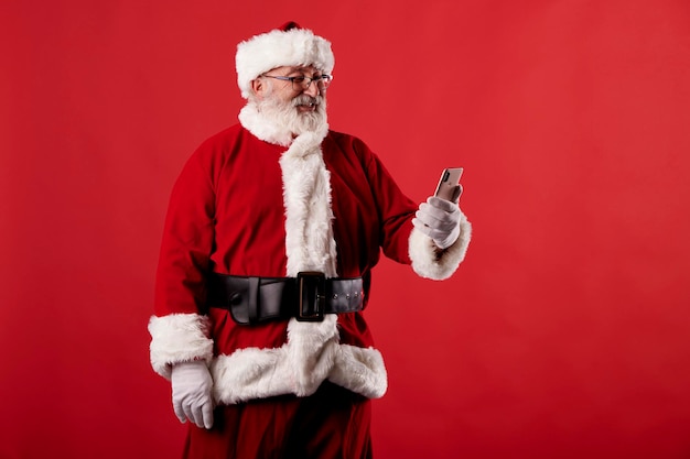 Santa Claus using a mobile phone on red background