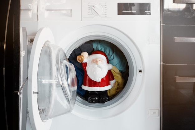 Photo santa claus in the washing machine. christmas.