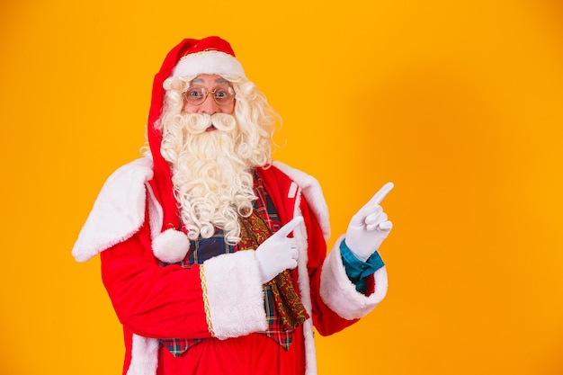 Santa Claus wijst naar de zijkant met ruimte voor tekst