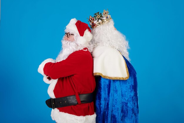 Santa claus and a wise king angry at each other on a blue background