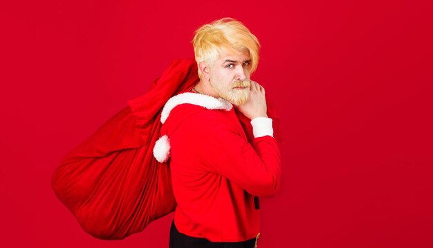 サンタクロースと大きなプレゼントバッグ新年の贈り物メリークリスマスひげを生やしたサンタの衣装で男